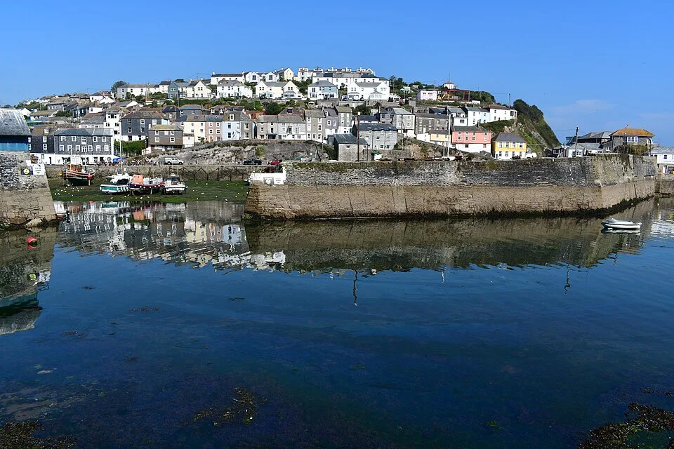 Il porto di Mevagissey in Cornovaglia, il paese a terrazze di case bianche e pastello sopra l’acqua calma